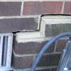 A closeup of a failed tuckpointing job where the brick cracked on a Hyannis home.