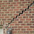 stair step cracking reaching from a window along the foundation wall in Framingham
