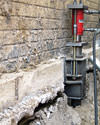 A completed installation of foundation push piers lifting a foundation in Plymouth