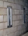 an inside view of foundation wall anchors installed along a basement wall to brace and repair the structure in Milton