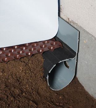 Closeup of a crawl space drainage system installed in New Bedford