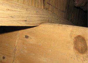 A failing girder showing signs of compression damage in a Massachusetts and Rhode Island home