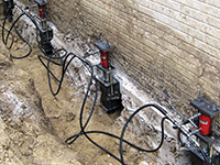 Using foundation push piers to lift a foundation during a repair in Amherst.
